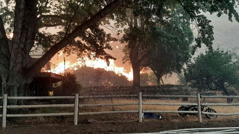 In this photo provided by Alison Oszman, a fast-moving wildfire...