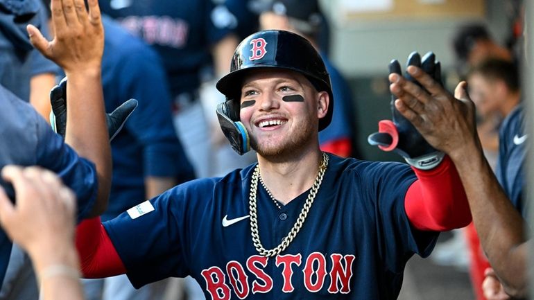 Alex Verdugo celebrates with Red Sox teammates after hitting a...