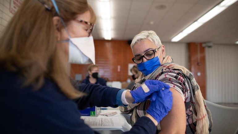 Dolce Rosario, 63, of Freeport is inoculated against COVID at a...