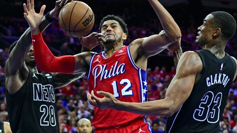 The 76ers' Tobias Harris and the Nets' Dorian Finney-Smith, left and Nic...