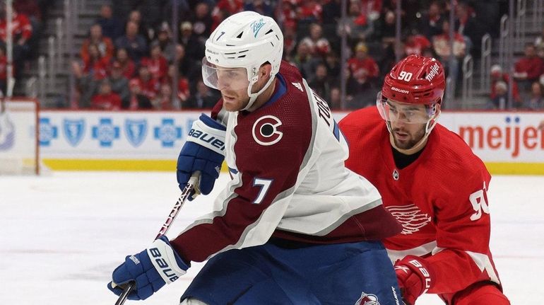 Devon Toews of the Avalanche heads up ice in front of...