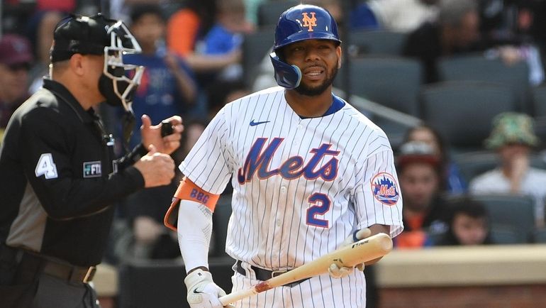 Mets designated hitter Dominic Smith reacts after he struck out...