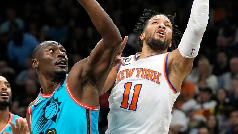 Knicks guard Jalen Brunson drives past Suns center Bismack Biyombo, center,...