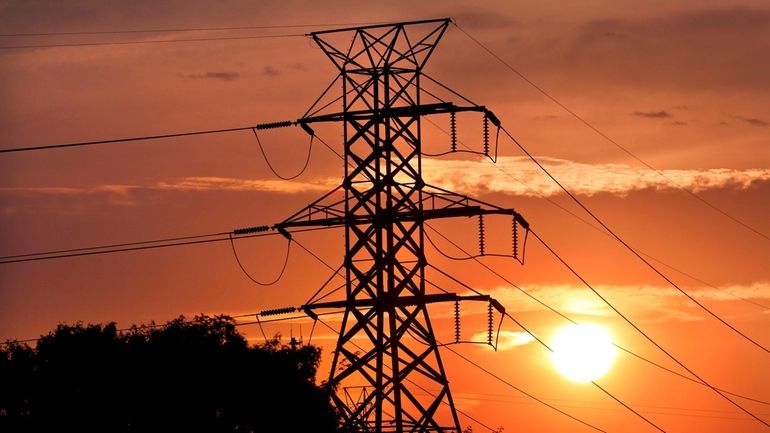 Towers carrying PSEG Long Island transmission lines are silhouetted by...