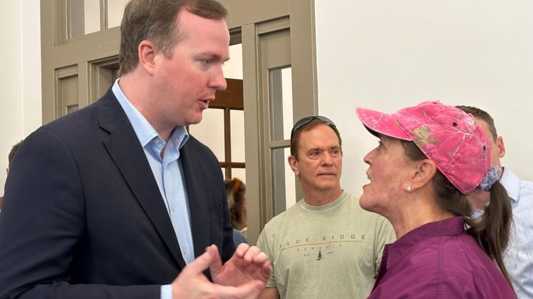 Republican Brian Jack speaks to a voter after a rally...