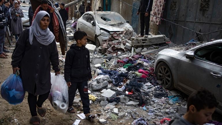 Palestinians look at the destruction after an Israeli airstrike in...