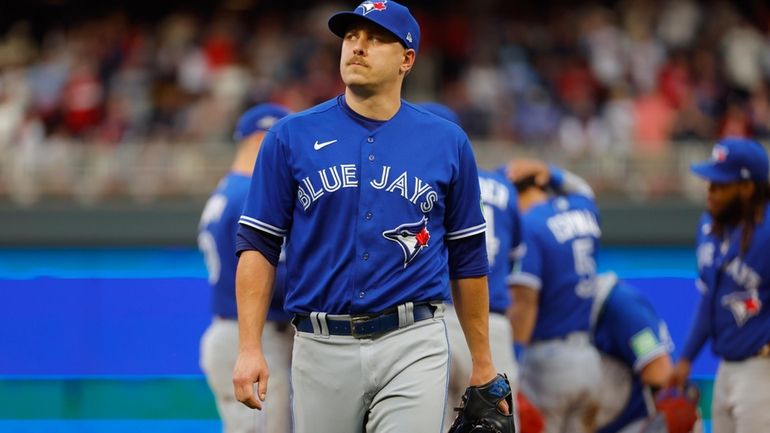 Toronto Blue Jays pitcher Erik Swanson walks to the dugout...