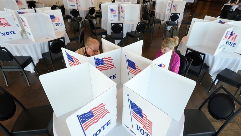 Voters fill out their ballots for the Michigan primary election,...