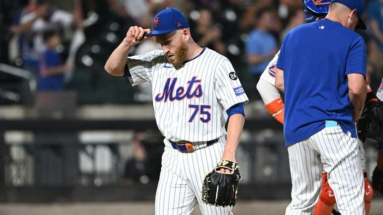 Mets relief pitcher Reed Garrett reacts as he walks off...