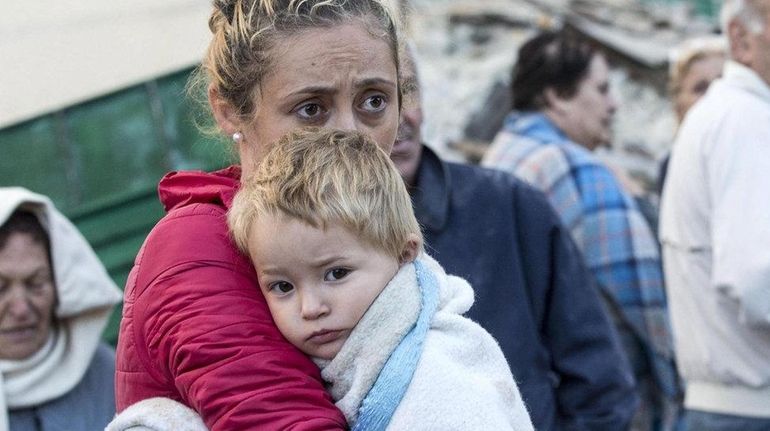 A mother embraces her son in Amatrice in central Italy...