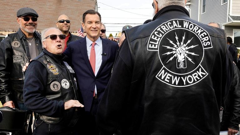 Former Rep. Tom Suozzi talks with supporters Saturday in Levittown. He...