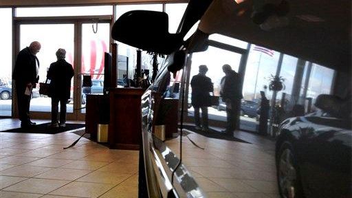 A car salesman speaks with a customer at the Apple...