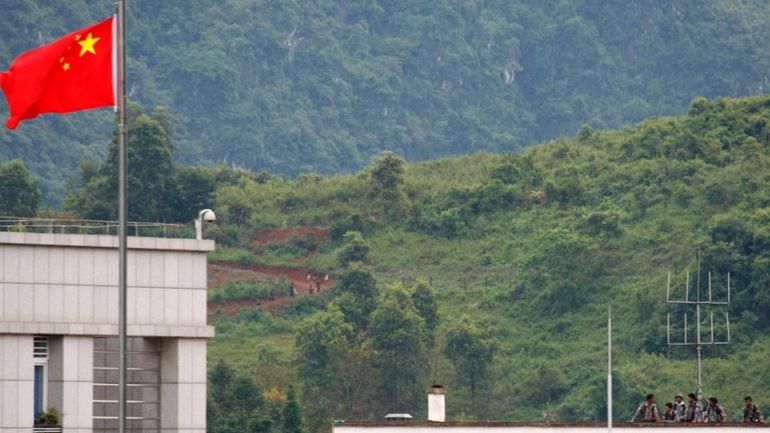 Myanmar government troops stand on a rooftop on the Myanmar...