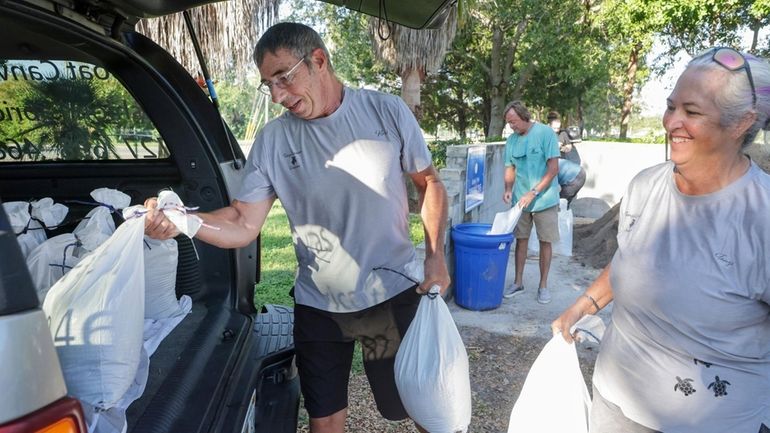 Karl Bohlmann, left, and Tangi Bohlmann, of Tarpon Springs, collect...