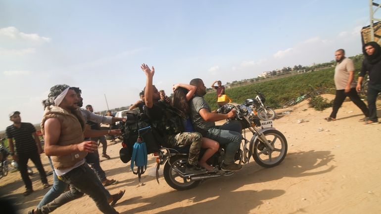 Palestinians transport a captured Israeli civilian, Noa Argamani, on a...