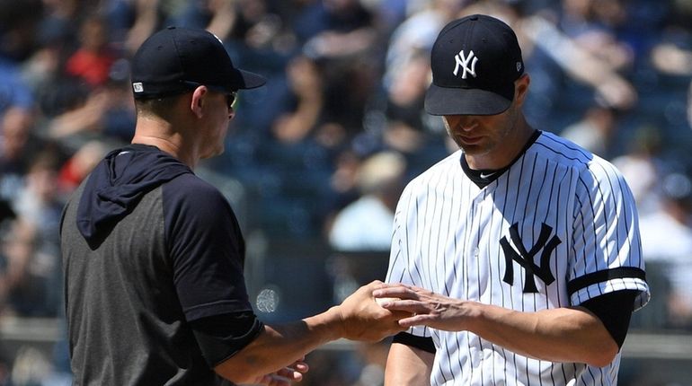 Yankees manager Aaron Boone takes the ball from starting pitcher...