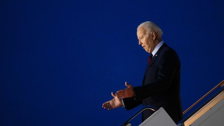 President Joe Biden reacts to people waiting for him at...