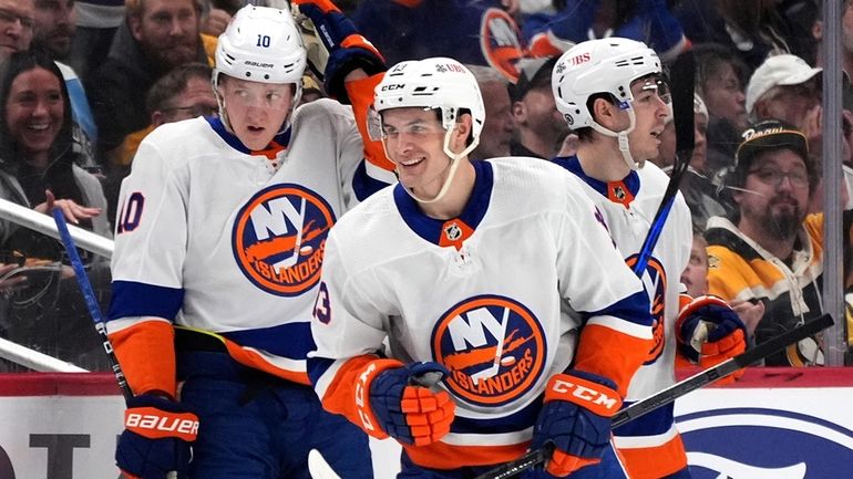 The Islanders' Mathew Barzal, center, heads back to the bench after...