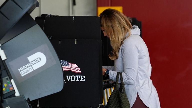 Voter Maria Mendoza completes her ballot for Florida's primary election...