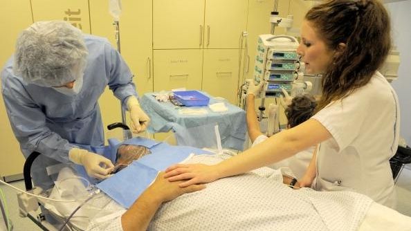 A doctor and a nurse prepare a patient possibly suffering...