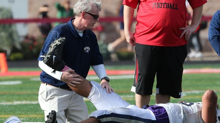 Longtime Bethpage High School trainer Joe Killeen, seen assisting a...