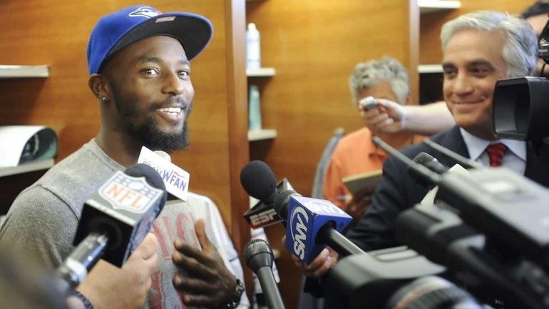 Jets wide receiver Santonio Holmes talks to the media after...