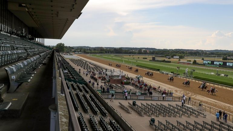 Horses parade in front of an empty grandstand a few...