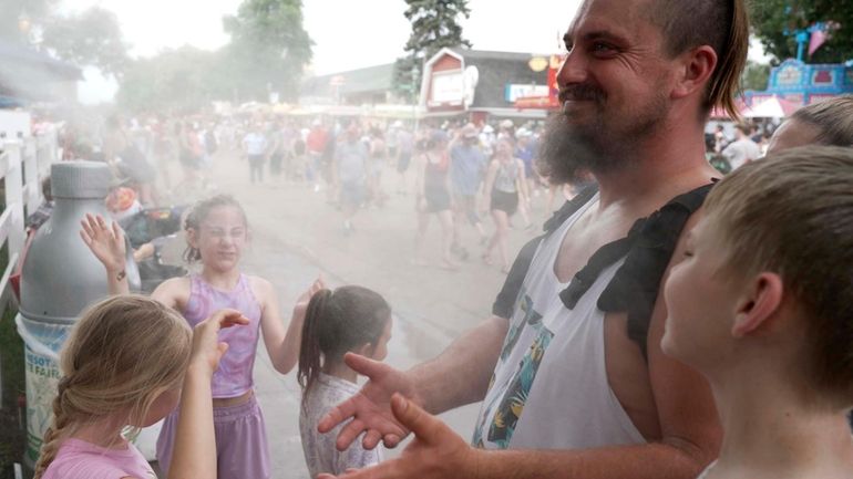 Seven-year-old Harper Perkins, center, and her sister Brielle, of Princeton,...