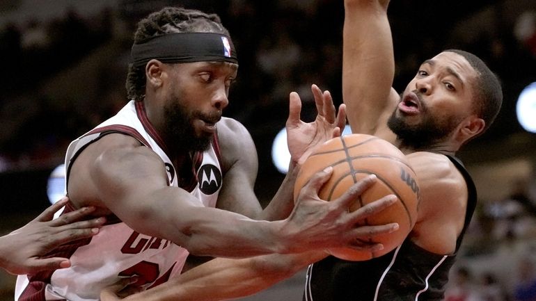 The Bulls' Patrick Beverley passes the ball past the Nets' Mikal...