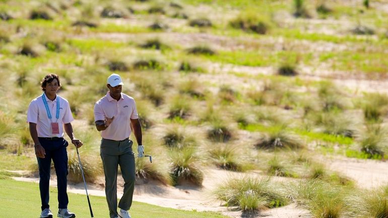 Tiger Woods walks with his son Charlie, on the sixth...