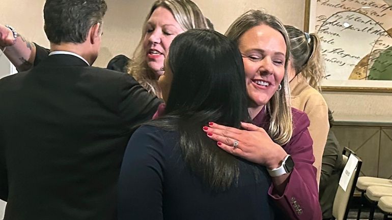 Attorney Kelly Fitzpatrick, right, hugs plaintiff Soryorelis Henry, foreground right,...