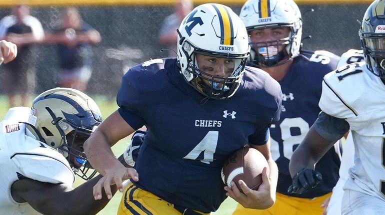 Paul Dulanto of Massapequa carries the ball against Baldwin during a...