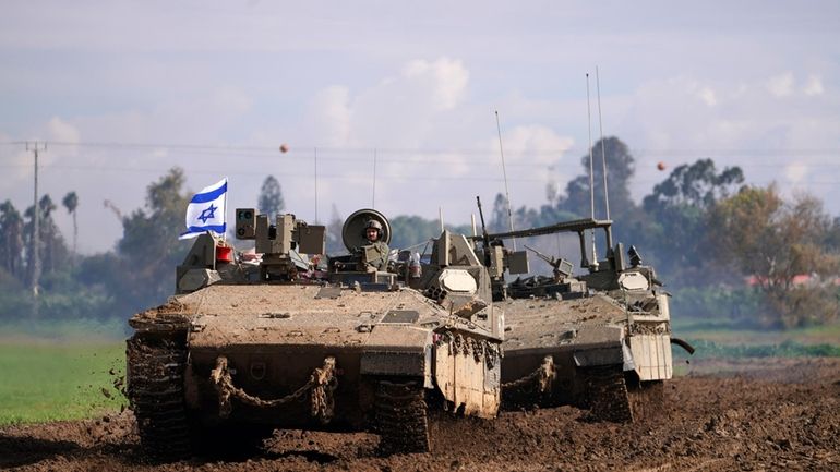 Israeli soldiers drive in their armored vehicles in southern Israel...