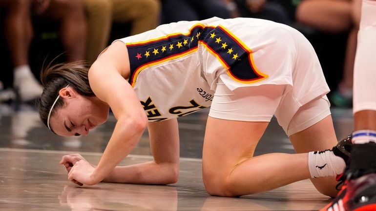 Indiana Fever guard Caitlin Clark (22) grimaces after being injured...