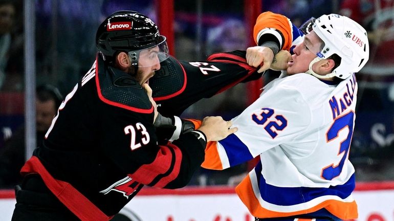 Kyle MacLean of the Islanders fights Stefan Noesen of the Hurricanes...