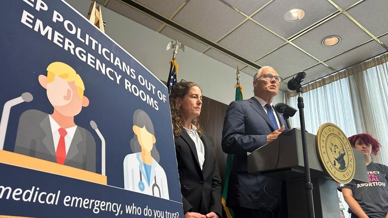 Washington Gov. Jay Inslee speaks to reporters during a news...