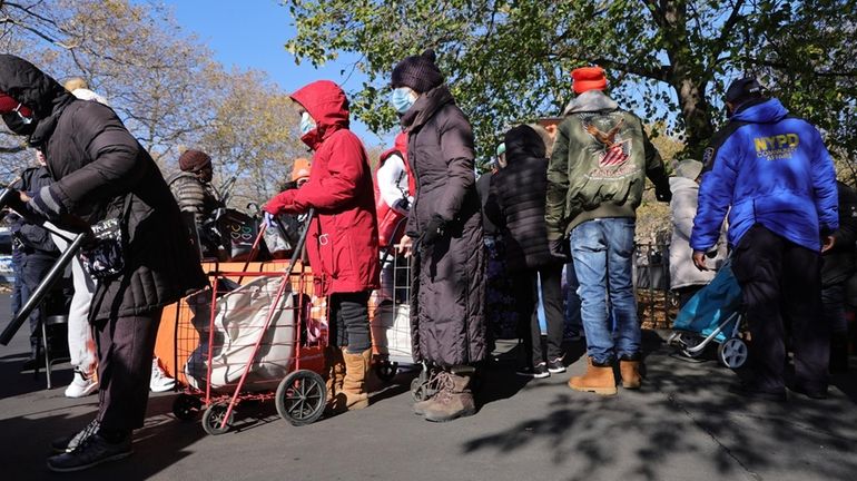 People attend a food bank pop-up Thanksgiving distribution event in...