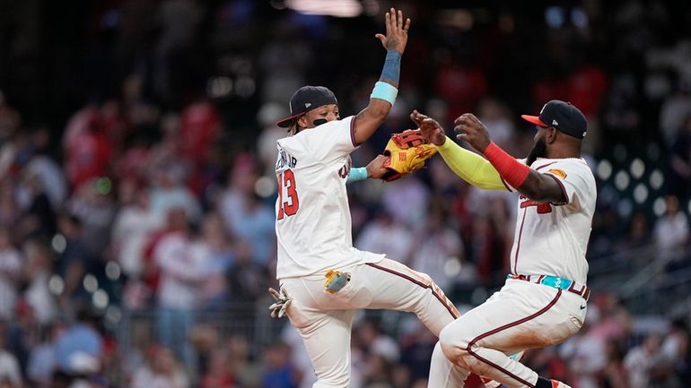 Atlanta Braves' Ronald Acuña Jr. (13) and Marcell Ozuna (20)...