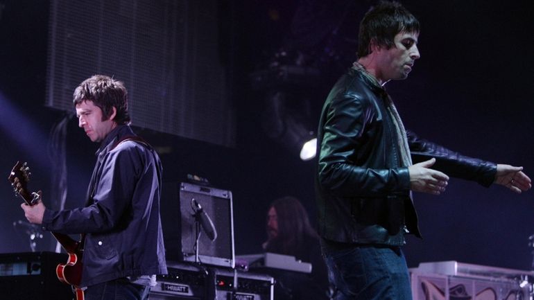 Noel, left, and Liam Gallagher, of Oasis, perform during the...