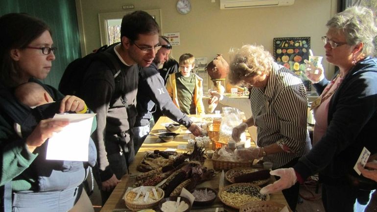 Volunteers point out the variety of popcorn flavors at the...