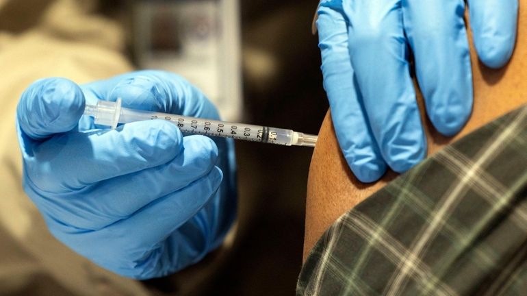 A shot is delivered at a Rochester COVID-19 vaccination site...