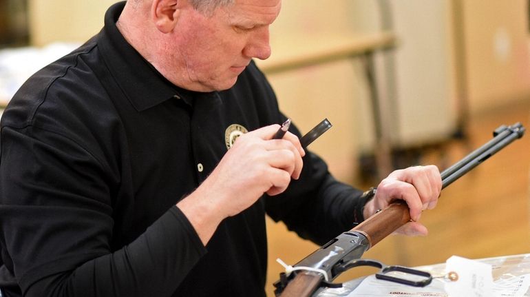 A Nassau County police detective with a lever-action rifle collected at...