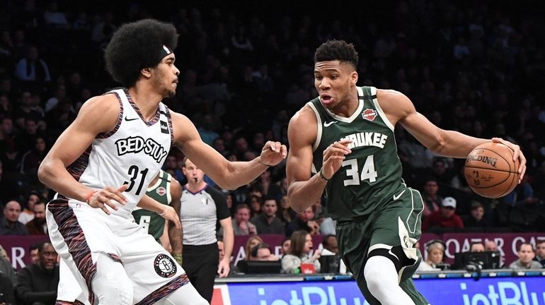 Milwaukee Bucks forward Giannis Antetokounmpo drives against Nets center Jarrett...