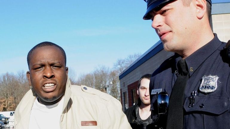 Evans Ganthier, 30, of Central Islip, is led out of...