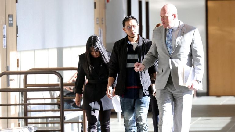 Jakeline Figueroa, left, leaves Suffolk County Court in Riverhead Tuesday...