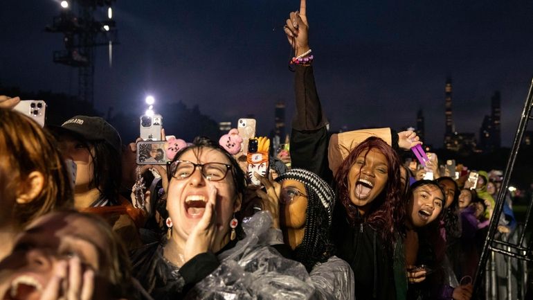 People react as South Korean singer Jungkook performs at the...