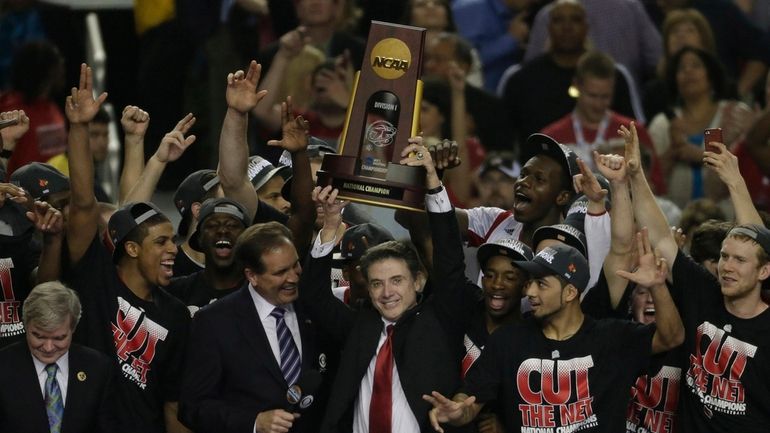 FILE - Louisville players and head coach Rick Pitino celebrate...