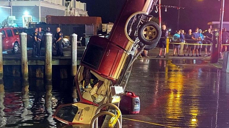 Bay Shore Fire Department rescue workers lift a pickup truck...