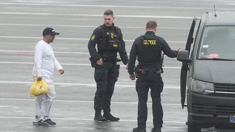 Danish police officers accompany financier Sanjay Shah as he arrives...