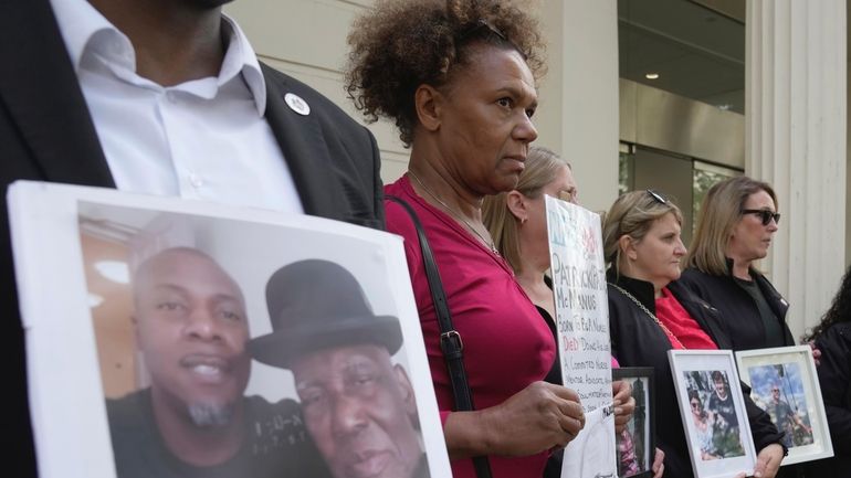 Loreli King holds up the pictures of her husband Vincent...